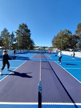 Pickleball game in progress across the net.