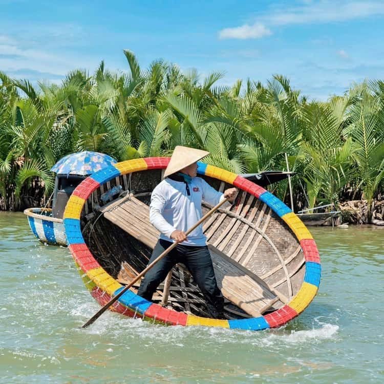 A guide paddles a traditional round basket boat through the nipa palms at Cam Thanh Coconut Village near Hoi An
