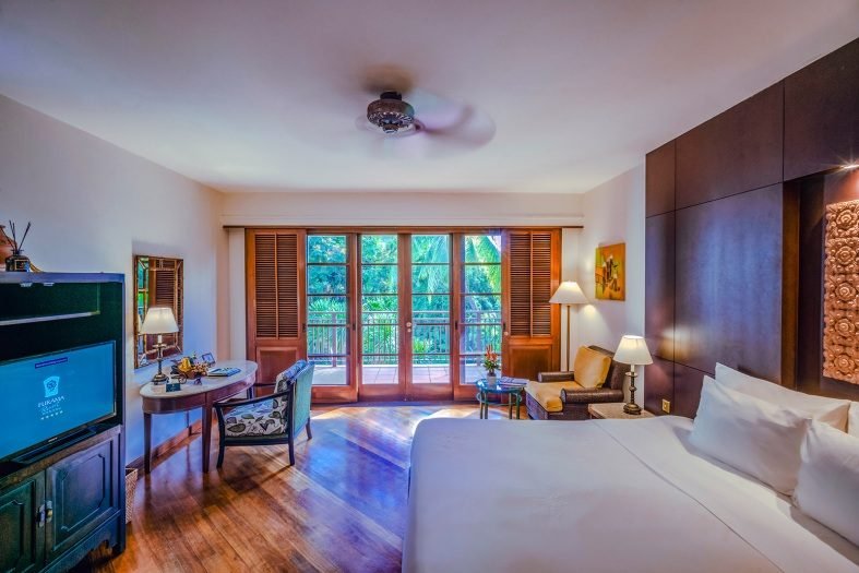 A Garden Superior room at the Furama Resort with shuttered windows onto the gardens