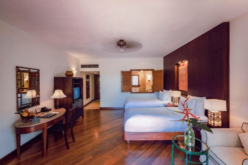 A Lagoon Superior room at the Furama Resort — dark timber, white linen and a desk by the window