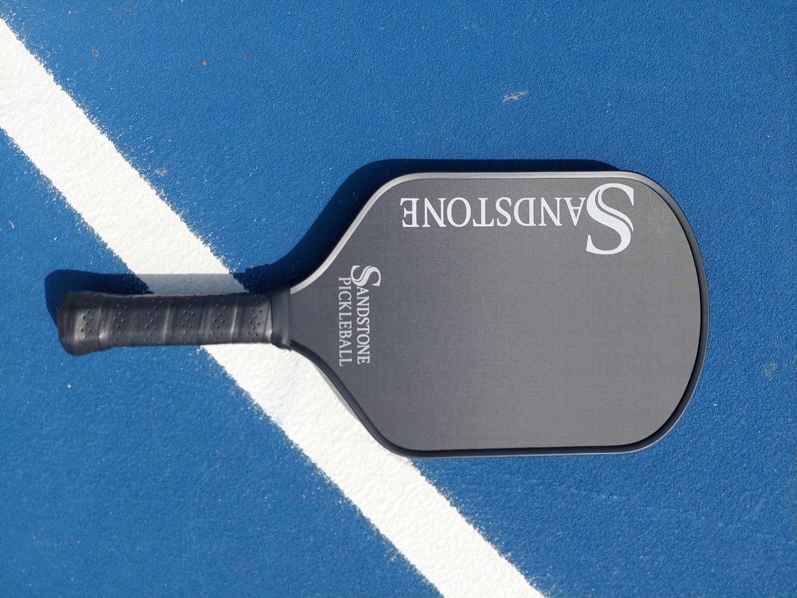 Sandstone Paddle on blue pickleball court