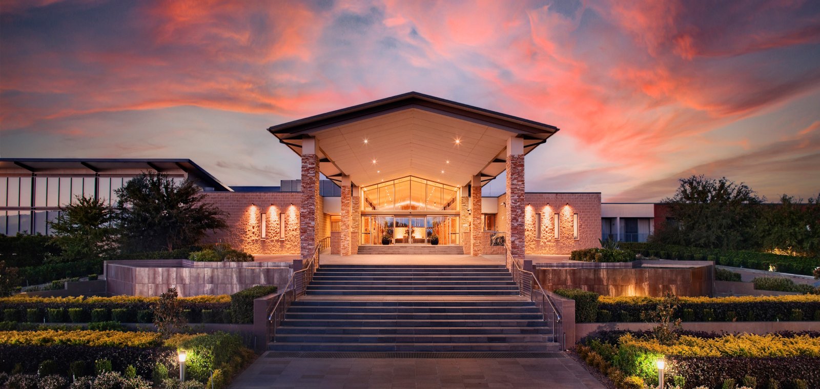 Rydges Resort grand entrance with stone pillars at sunset